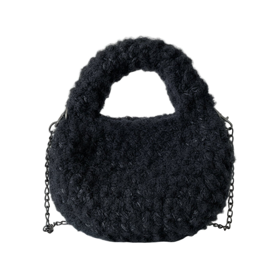 Dark gray fluffy bag on a white mannequin with a chain detail.