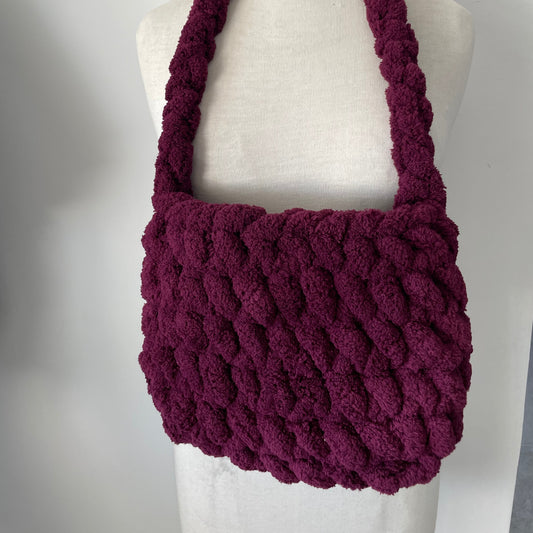 Purple knitted bag on a mannequin with a white background