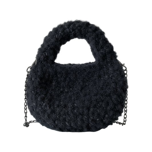Dark gray fluffy bag on a white mannequin with a chain detail.